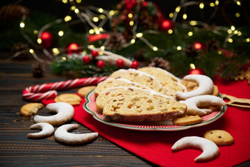 Slices of Traditional Christmas stollen cake with marzipan and dried fruit and New Year decorations