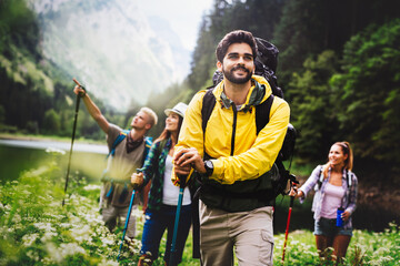 Group of happy friends with backpacks hiking together