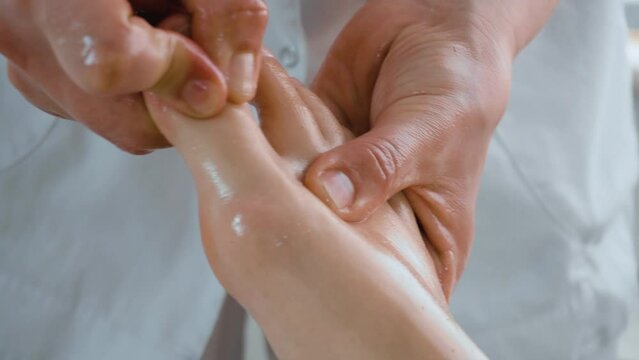 Procedure feets and fingers massage in spa salon close up. Concept of body care and alternative medicine