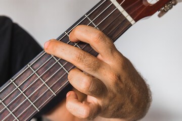 A left hand that play G Major on acoustic guitar