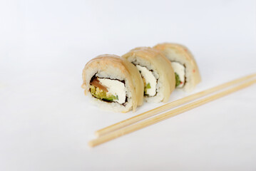  three pieces of sushi and chopsticks on white