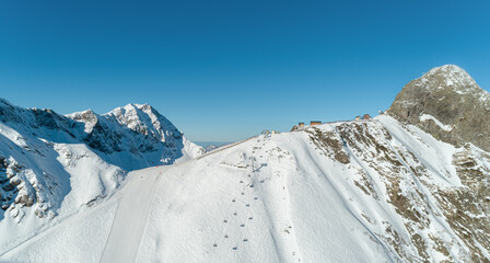 Sochi Ski Area Winter Snow Mountain Peaks Panoramic Aerial View. Ski slope from air. Winter landscape from a drone. Snowy landscape on ski resort. Aerial drone photography