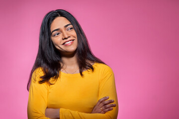 Fototapeta premium Portrait of a happy young woman looking elsewhere with hands crossed