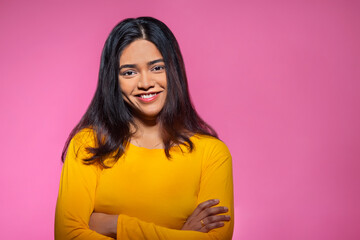 Fototapeta premium Portrait of a happy young woman looking at the camera with hands crossed