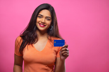 Young woman showing credit card in front of camera with smile