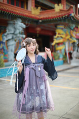 Beautiful young woman with dark blue Chinese lolita dress with Chinese garden