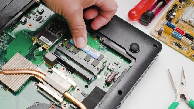 Computer engineer installing DDR RAM memory into Slot, laptop upgrades