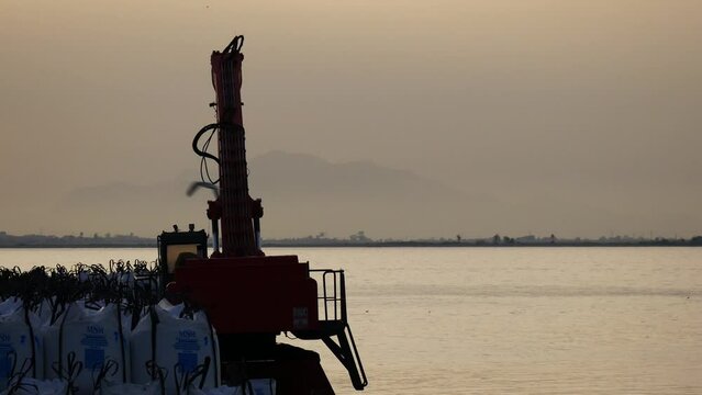 Sacks of sea salt waiting at Santa Pola&acute;s port to be loaded next to a crane. Alicante, Spain