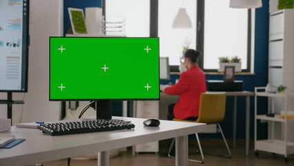 Green screen on computer in business office. Empty desk with chroma key template and isolated mock...
