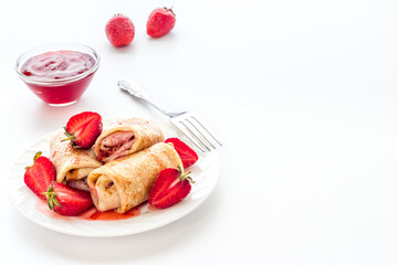 Sweet breakfast - rolled pancakes with strawberry and berry sauce