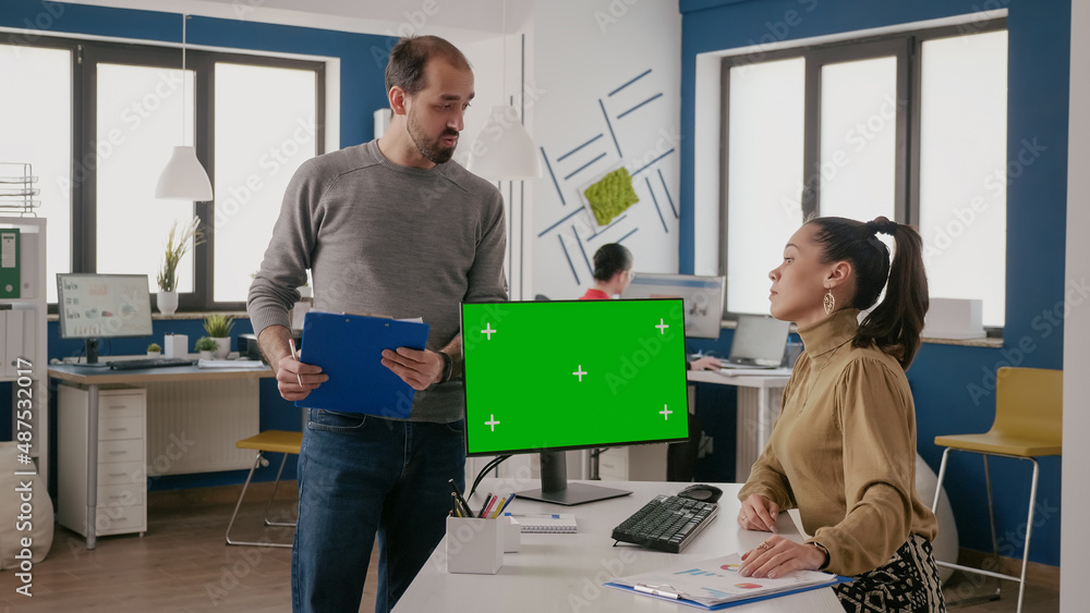 Poster team of coworkers using computer with green screen in startup office. man and woman working with iso