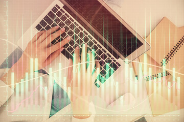 Double exposure of woman hands working on computer and forex graph hologram drawing. Top View....