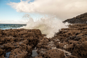 Powerful ocean wave hit rough stone coast creating splash of water. West coast of Ireland. Burren area. Irish landscape.