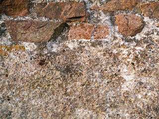 Old wall texture with vintage bricks and weathered concrete plaster. Warm tone. Copy space. Abstract design background.