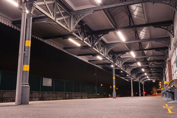 Empty platform of a rail train station. Old vintage design. Low angle shot. Cobh, Ireland. Nobody. Night shot.