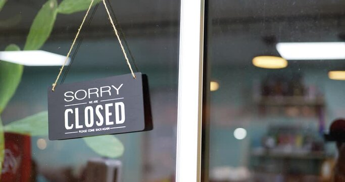 On the door of a caf&eacute;, there is an closed sign.