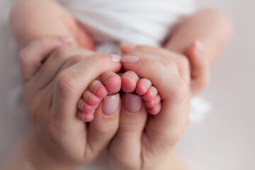 tiny baby newborn feet and fingers in mothers hands