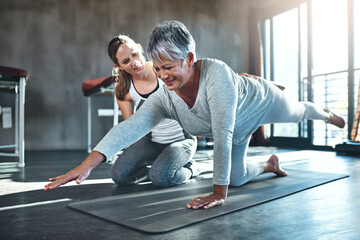 Working together to improve muscle strength and tone. Shot of a senior woman working out with her...