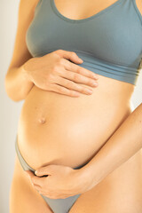 pregnant woman holding her belly with her hands