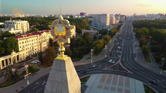 Aerial close-up of ussr sign on top of monument on victory square in the center of Minsk, Belarus. Sunset on a summer day.  
