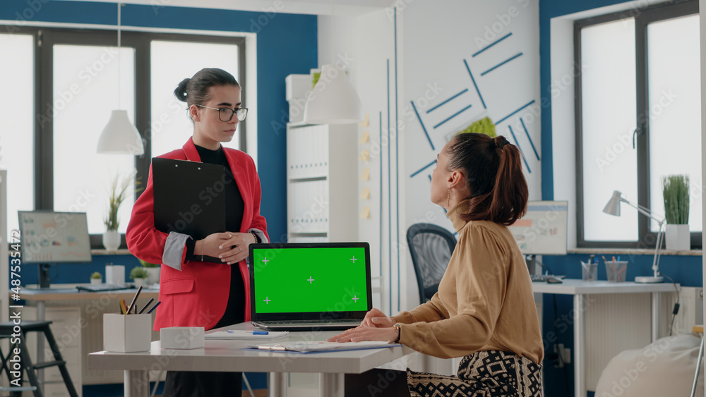 Poster business women working with green screen on laptop in startup office. colleagues using computer with