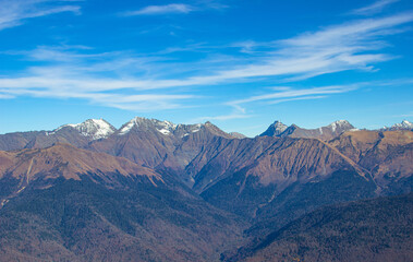 Obraz na płótnie Canvas Beautiful mountain landscapes with stone peaks and forests in valleys against a bright blue sky. Rose Peak in Sochi, Russia