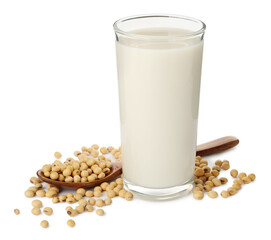 Glass of fresh soy milk and spoon with beans on white background