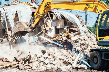 Excavator breaks old house. Process of demolition building. Construction industry and development...