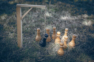 The black chess pawn on the gallows after defeat, pawn pieces are standing nearby. The concept of uprising, revolution. Selective focus