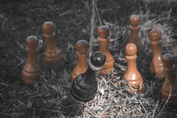 The black chess pawn was hung from the gallows. She is executed by the enemy - white pawns. The concept of violence, racism, stalking, persecution, murder