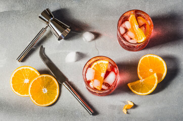 Italian aperitif red cocktail Campari with orange and ice copy space for text grey background.