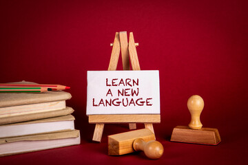 Learn a New Language. Stack of books and stamps on a red background