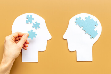 Communication. Chaos and peace in brain - two paper human heads with puzzles