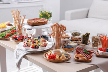 Dishes with different food on table in living room. Luxury brunch