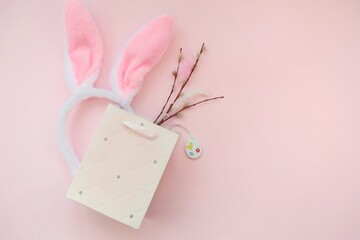 Pink bag, bunny headband and willow branches on a pink background.The concept of Easter, shopping for Easter. 