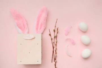Pink bag, bunny headband and willow branches on a pink background.The concept of Easter, shopping for Easter. 