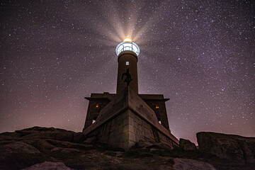 Panoramic view of Nariga lighthouse, in Malpica, under a starry winter night with many stars. High quality photo
