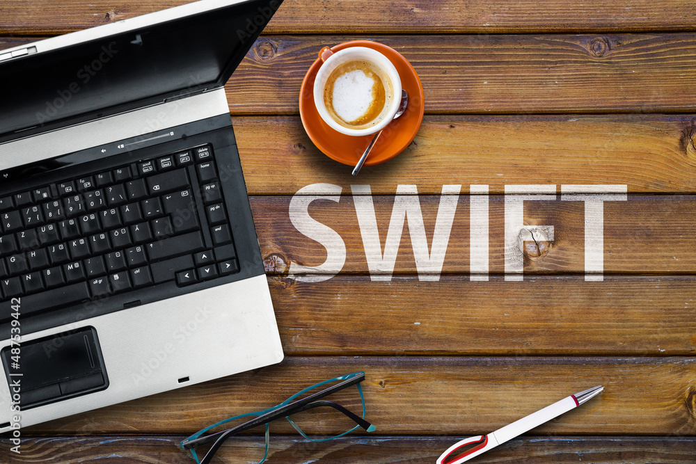 Aufkleber swiftl programming language. word swifton wooden desk and laptop