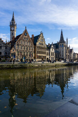 Fototapeta na wymiar Panoramic of Ghent next to the water channels, with the reflection of the buildings in the water, on a sunny day.