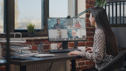 Employee talking to workmates on online video call, meeting to discuss business project. Woman using remote teleconference on computer with colleagues. Video conference on webcam - obrazy, fototapety, plakaty