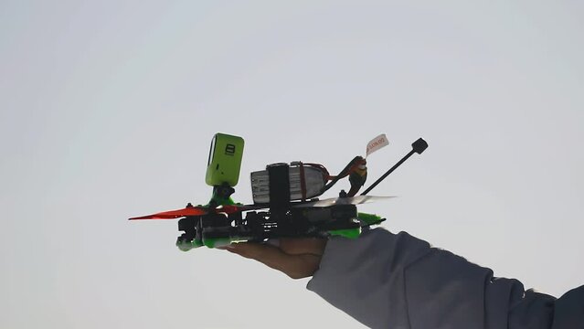 A quadrocopter takes off from the girl's hand and flies up. Taken in close-up