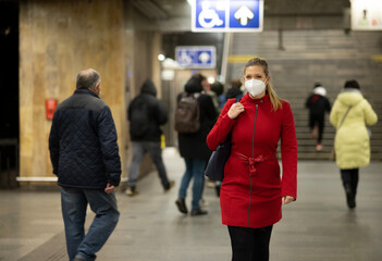 Woman walks in underground with protection mask. Business travel concept.