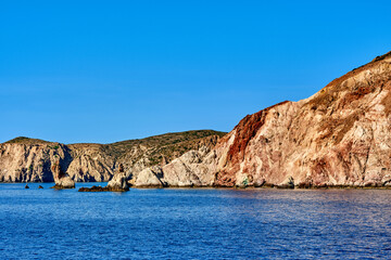 Fototapeta na wymiar Beautiful view of high hill slope of island in Mediterranean Sea. Blue waters, clear blue sky, bright sunshine, summer day, rocks and islets