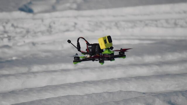 The camera follows a drone that flies low above the ground. Filmed in the winter forest