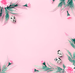 Easter composition. Easter eggs, flowers, paper blank on pastel pink background. Flat lay, top view, copy space.