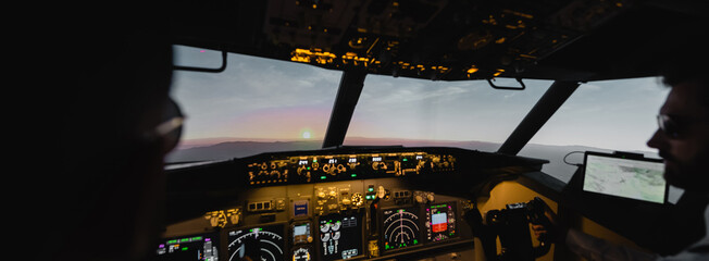 blurred professionals piloting airplane in evening during sunset, banner. © LIGHTFIELD STUDIOS