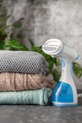 Portable home and travel garment steamer for clothes. Clothes pile. Housework