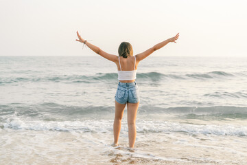 Woman on the shore of the beach from behind