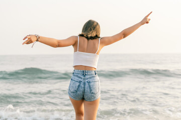 Woman on the shore of the beach from behind