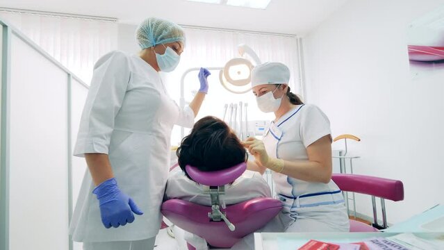 A patient is having her teeth treated by doctors